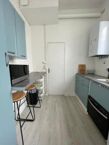 eine Küche mit blauen Schränken und einer Arbeitsplatte in der Unterkunft Appartement à 200 mètres de la gare in Rouen