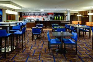 um restaurante com cadeiras e mesas azuis e um bar em Courtyard Atlanta Airport West em Atlanta