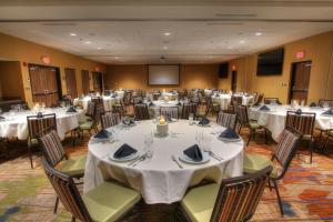 a banquet hall with white tables and chairs and a screen at Courtyard by Marriott Gatlinburg Downtown in Gatlinburg