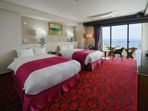 two beds in a hotel room with a red carpet at Hotel Resonex Nago in Nago +119 photos