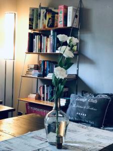 un vaso con fiori bianchi su un tavolo di A Room for You a Ferrara
