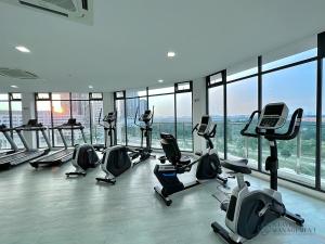 a gym with a bunch of treadmills and exercise bikes at The Elysia Suites in Nusajaya