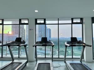 a gym with two treadmills in front of a window at The Elysia Suites in Nusajaya