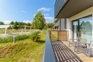 een veranda van een huis met een bank bij Apartament WIND SurfingBird Dźwirzyno in Dźwirzyno