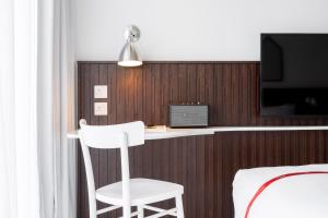 a room with a desk and a chair and a tv at Ruby Zoe Hotel London in London