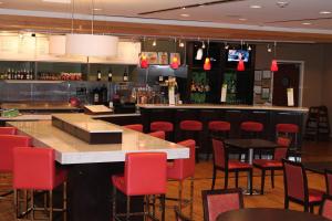 un bar en un restaurante con sillas rojas y una barra en Courtyard by Marriott Vicksburg, en Vicksburg