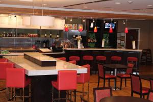 a bar in a restaurant with red chairs and a counter at Courtyard by Marriott Vicksburg in Vicksburg
