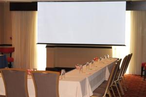 a long table with chairs and a large screen at Courtyard by Marriott Vicksburg in Vicksburg