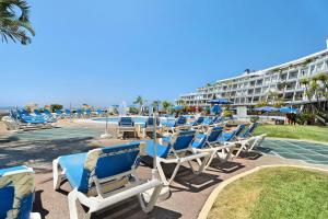 a row of blue chairs sitting on a beach at La Quinta in Santa Úrsula