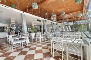 a restaurant with white tables and white chairs at La Quinta in Santa Úrsula