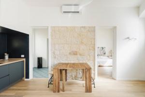 een keuken en eetkamer met een houten tafel bij BassaMarea - Una sorpresa in Centro storico in Carloforte