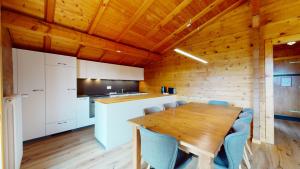 Il comprend une cuisine et une salle à manger avec une table et des chaises en bois. dans l'établissement Apartment with spectacular view of the peaks, à Crans-Montana