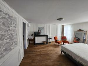 1 Schlafzimmer mit einem Bett, 2 Stühlen und einem Schreibtisch in der Unterkunft LE ZOLA in Bourges