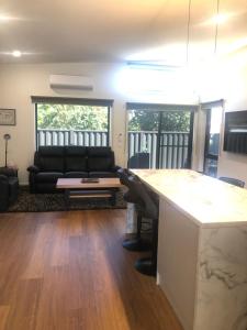 ein Wohnzimmer mit einem schwarzen Sofa und einem Tisch in der Unterkunft Luxe & Superior 2BR Villas Patio Free Parking & Wifi in Launceston