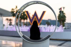 a person sitting in a chair in front of a wii sign at W Abu Dhabi - Yas Island in Abu Dhabi