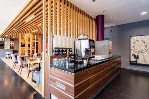 a bar in a restaurant with a counter and chairs at Premier Inn Stuttgart Airport in Leinfelden-Echterdingen