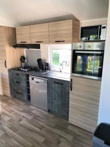 a kitchen with stainless steel appliances and wooden cabinets at Tussen ´Zee & Meer´ in Lauwersoog