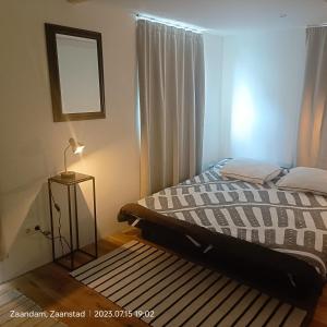 een slaapkamer met een bed en een raam met een tapijt bij Double room in private home in Zaandam