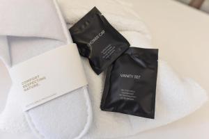 dos paquetes negros de odorizantes sentados en una toalla blanca en BDB Rooms Trastevere, en Roma