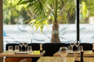 a row of wine glasses on tables in a restaurant at Crowne Plaza - Marseille Le Dôme in Marseille