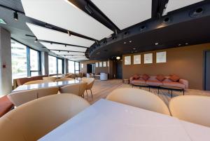 a waiting room with tables and chairs and windows at Crowne Plaza - Marseille Le Dôme in Marseille
