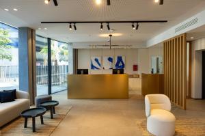 an office lobby with a reception desk and chairs at Crowne Plaza - Marseille Le Dôme in Marseille