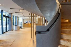 a lobby with a staircase in a building at Crowne Plaza - Marseille Le Dôme in Marseille