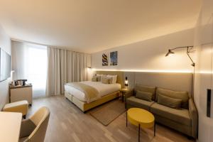 a hotel room with a bed and a couch at Crowne Plaza - Marseille Le Dôme in Marseille