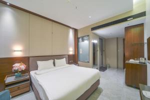 a bedroom with a large white bed and a desk at Hotel Devgiri Inn and Restaurant in Sāngli