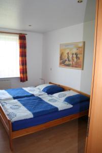 um quarto com uma cama com um edredão azul em Ferienwohnung Ehmsen em Groß Vollstedt