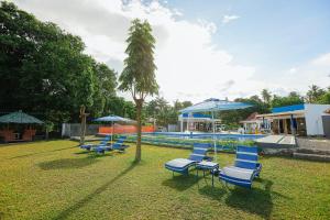 a group of blue chairs and umbrellas next to a swimming pool at B Ternate Resort in Dauin