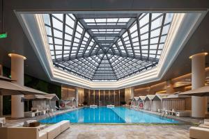 a large swimming pool with a large ceiling at Hangzhou Junsun Luxury Hotel in Hangzhou