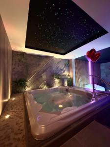 a large bath tub in a bathroom with a star ceiling at Les Secrets Rooms - Bonneval - Love Room - Spa et Hammam Privatif in Bonneval
