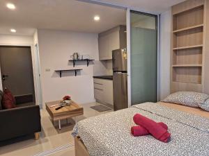 a bedroom with a bed with a red pillow on it at Mantra condominium in Ban Tha Fat