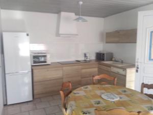 a kitchen with a table and a white refrigerator at Studio in La Canourgue