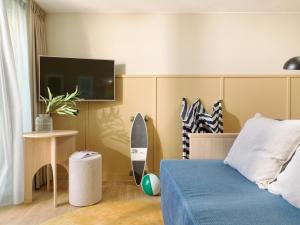 a bedroom with a bed and a surfboard on the wall at Carlton Beach in Scheveningen