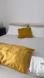 Cataleya Baia del Carpino Scalea في سكاليا: سرير ابيض وعليه بطانيه صفراء