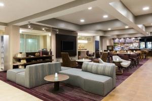 a hotel lobby with couches and tables and a bar at Courtyard Dallas Mesquite in Mesquite