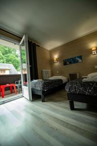 una camera con 2 letti e una porta scorrevole in vetro di Hotel La Chaumiere a Saint-Gervais-les-Bains