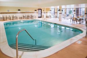 a pool at a hotel with tables and chairs at Courtyard Largo Medical Center Drive in Largo