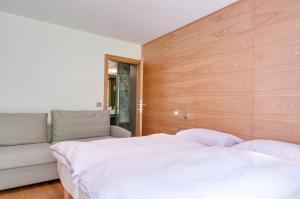 sypialnia z białym łóżkiem i kanapą w obiekcie B&B Il Sorriso Dei Nonni w mieście Pracorno di Rabbi