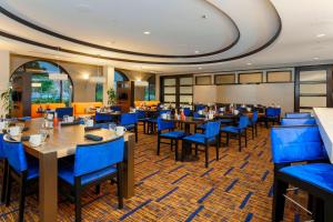 聖地牙哥的住宿－聖地亞哥機場/自由站萬怡酒店，一间配备有桌子和蓝色椅子的用餐室