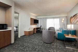 a hotel room with a blue couch and a desk at Courtyard Dallas Mesquite in Mesquite