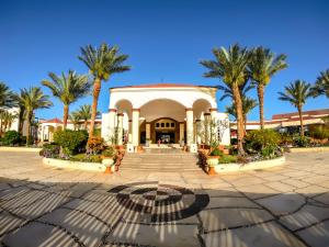 ein Gebäude mit Palmen im Innenhof in der Unterkunft Regency Plaza Aqua Park and Spa Resort in Sharm El Sheikh
