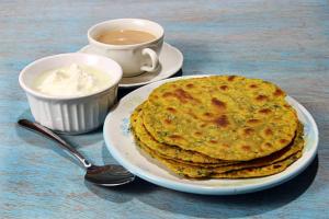 a plate with a stack of pancakes and a cup of coffee at Shivalik Camping & Cottage, Joshimath in Joshīmath