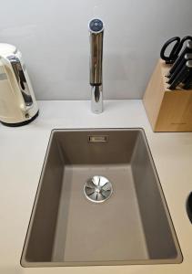 - un évier de cuisine avec un robinet en chrome sur un comptoir dans l'établissement Boutique Suites Sylt - Kliffkante - Opening August 2023, à Kampen