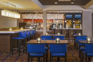 a restaurant with blue chairs and tables and a bar at Courtyard by Marriott Richmond Northwest in Henrico