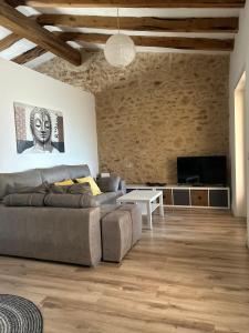 ein Wohnzimmer mit einem Sofa und einem TV in der Unterkunft Via ca´ls Avis in Campredó