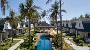 an aerial view of a resort with a pool and palm trees at Jambuluwuk Oceano Gili Trawangan in Gili Trawangan