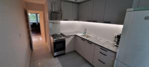 a white kitchen with a stove and a sink at Apartament na 11go in Płock